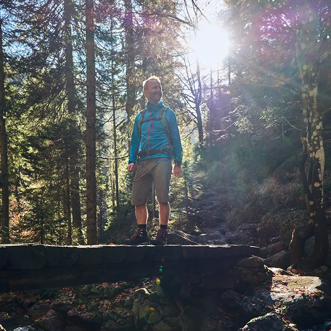 Wanderer auf einer Brücke über einen plätschernden Bach Wanderer