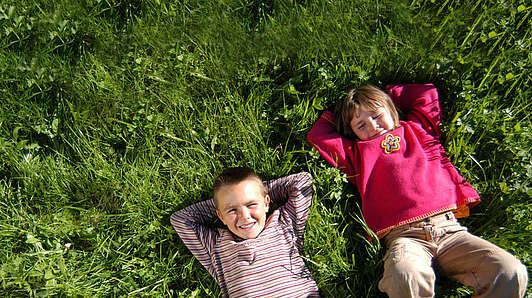Children lying in the meadow in the Bavarian Forest National Park holiday region