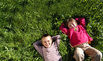 Kinder in der Wiese liegend in der Ferienregion Nationalpark