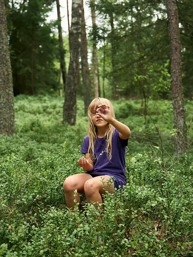 Kind sitzt im Wald