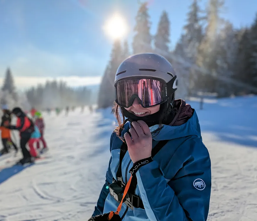Lächelnde Skifahrerin mit Helm genießt den sonnigen Wintertag am Großen Arber
