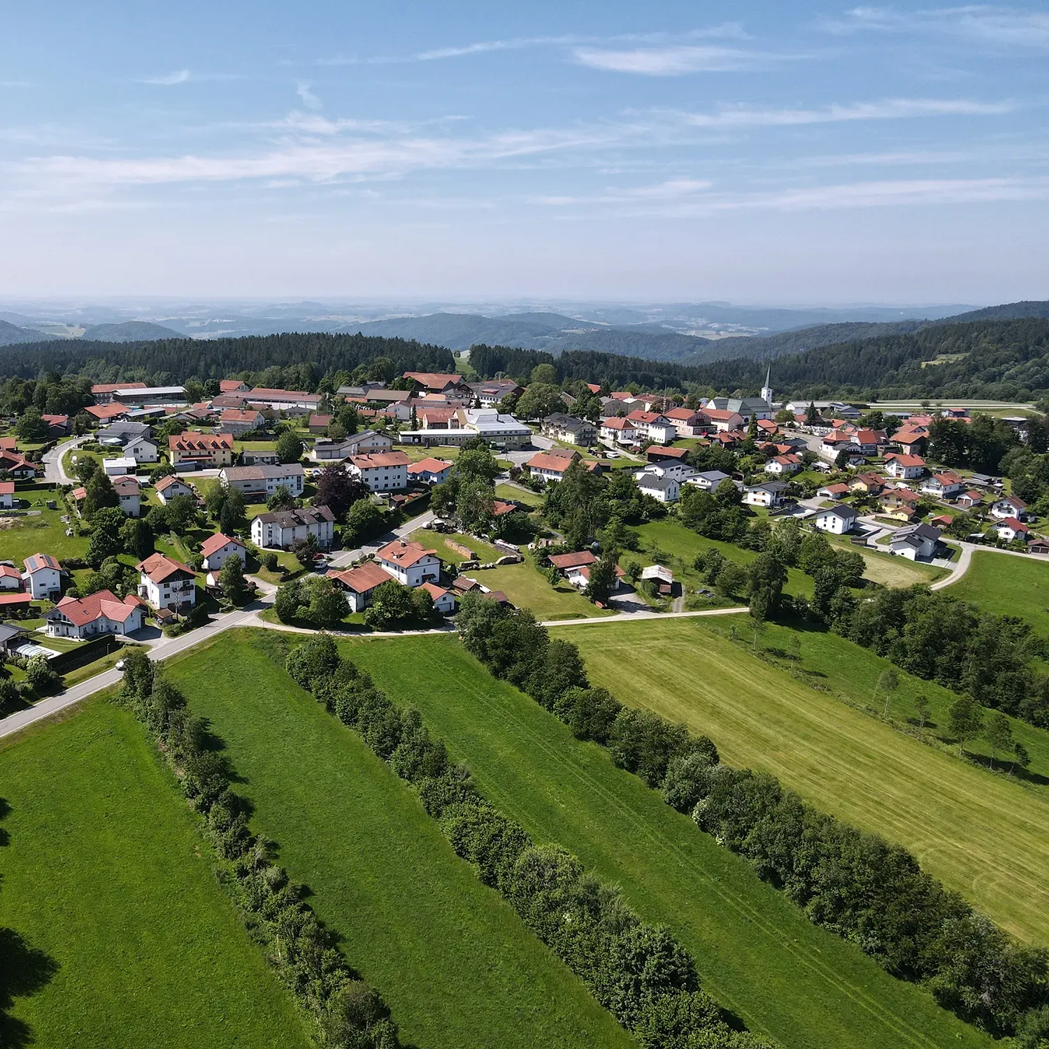 Luftbildaufnahme der Gemeinde Hohenau mit saftig grünen Wiesen und blauem Himmel Gemeinde Hohenau mit grünen Wiesen und blauem Himmel aus der Luft aufgenommen