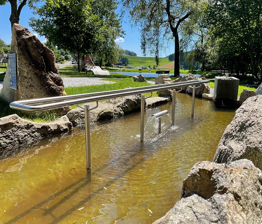 Ruhige Oase am Kneippbecken mit Handlauf, mit viel Wasser und frischen Laubbäumen umgeben Kneippbecken Klopferbach