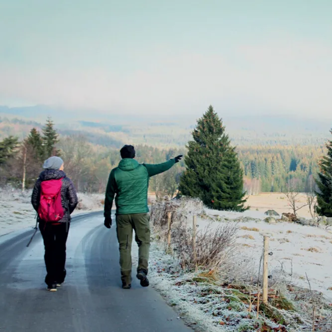 Zwei Wanderer genießen die winterliche Aussicht auf den romantischen Böhmerwald Wandern im Sumava