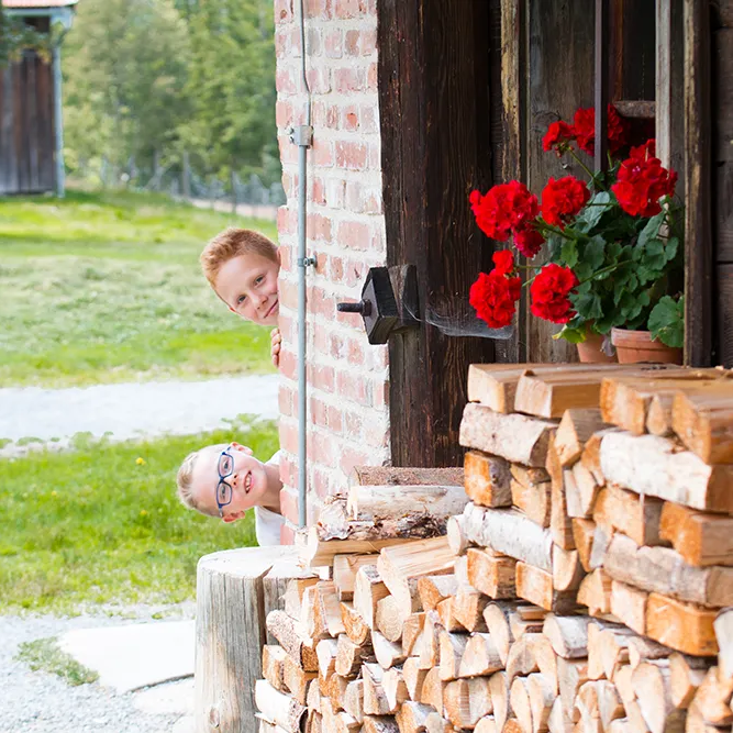 Ländliche Idylle mit spielenden Kindern und klassischer Geranienbepflanzung im Freilichtmuseum Finsterau Kinder im Freilichtmuseum Finsterau