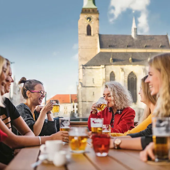 Gemütliches Treffen im Biergarten vor der historischen Kirche von Pilsen Biergenuss in Pilsen