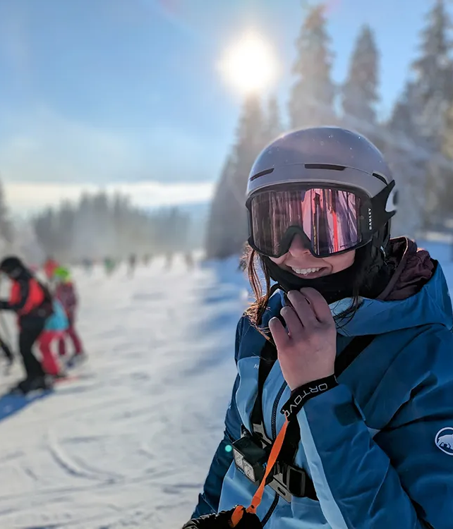 Lächelnde Skifahrerin mit Helm genießt den sonnigen Wintertag am Großen Arber