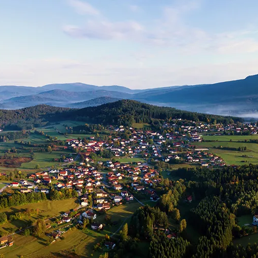 Lindberg eingebettet in ein grünes Kleinod, umgeben von einer ruhigen, idyllischen Naturkulisse und Waldwogen.
