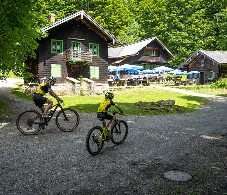 Mountainbiker kurz vor der zum Verweilen einladender Racheldiensthütte im Nationalpark Bayerischer Wald