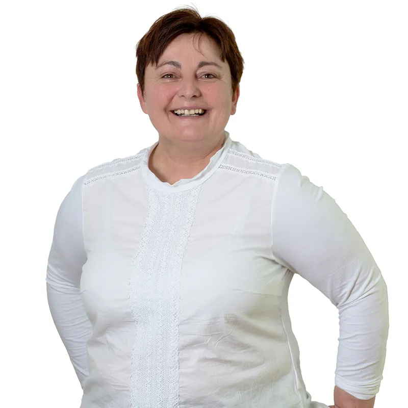 Mitarbeiterin der Tourist-Info Bayerisch Eisenstein, Heidi Kraus-Mühlbauer, lächelnd und schick gekleidet in weißem Oberteil. Heidi Kraus-Mühlbauer
