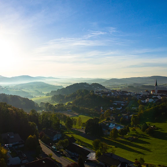 Ein weites Panorama rund um Schönberg, das in der diesigen Morgenbeleuchtung erstrahlt mit blauem Himmel.