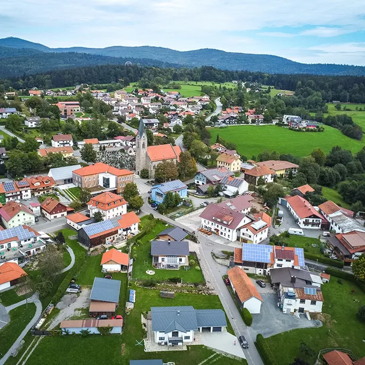 Luftaufnahme der Gemeinde Neuschönau im Sommer Gemeinde Neuschönau mit Kirche im Mittelpunkt