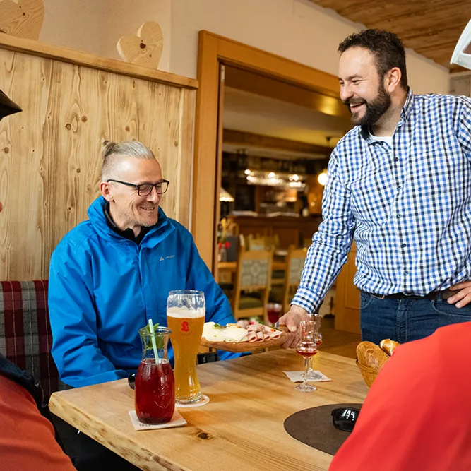 Gemütliche Pause beim Radfahren im lokalen Restaurant Die entspannte Atmosphäre zeigt Radfahrer, die nach einer Tour in einem Restaurant eine Mahlzeit und Getränke genießen.