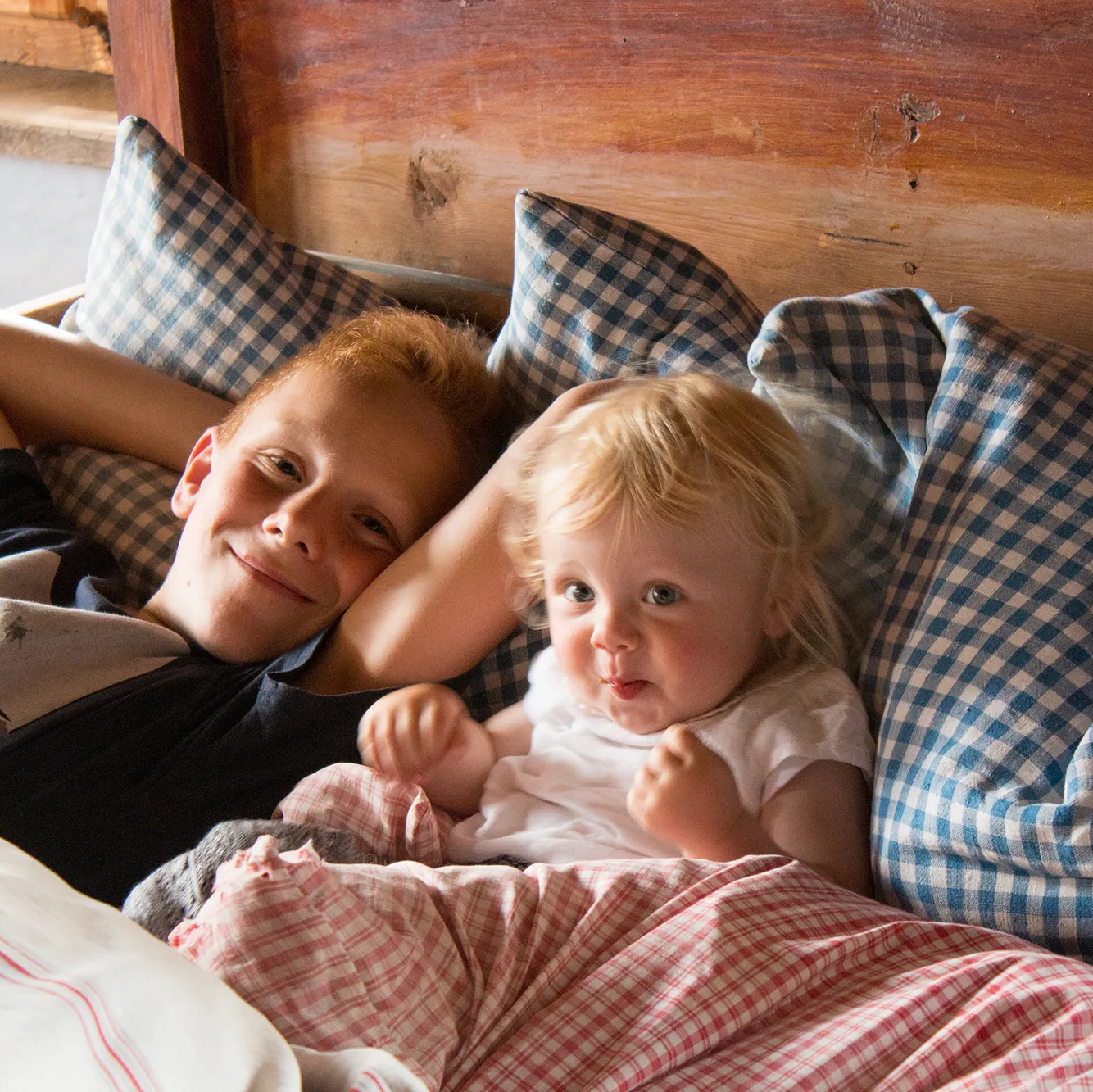 Kleine Kinder spielen in einem Holzbett Kinder im Bett