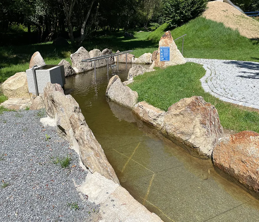 Becken der Kneippanlage am Klopferbach umgeben von Natur und Steinen Kneippanlage