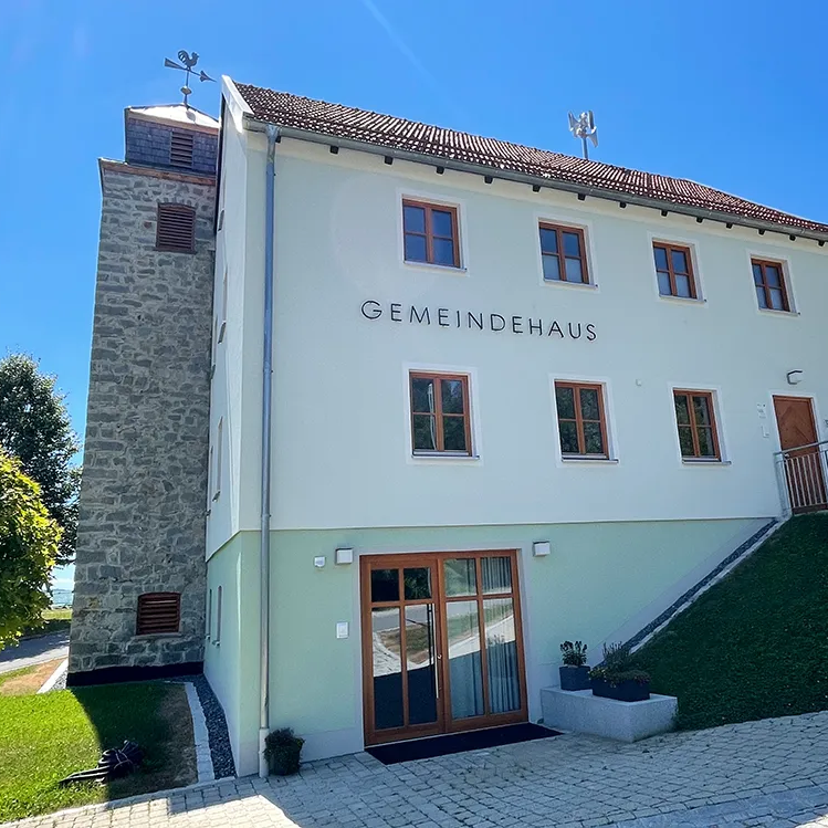 Modernes Gemeindehaus Eppenschlag unter strahlend blauem Himmel Das Gemeindehaus in der Ferienregionsgemeinde Eppenschlag, umgeben von Bäumen und einem gepflegten Garten, strahlt Ruhe und Gemeinschaftsgefühl aus.
