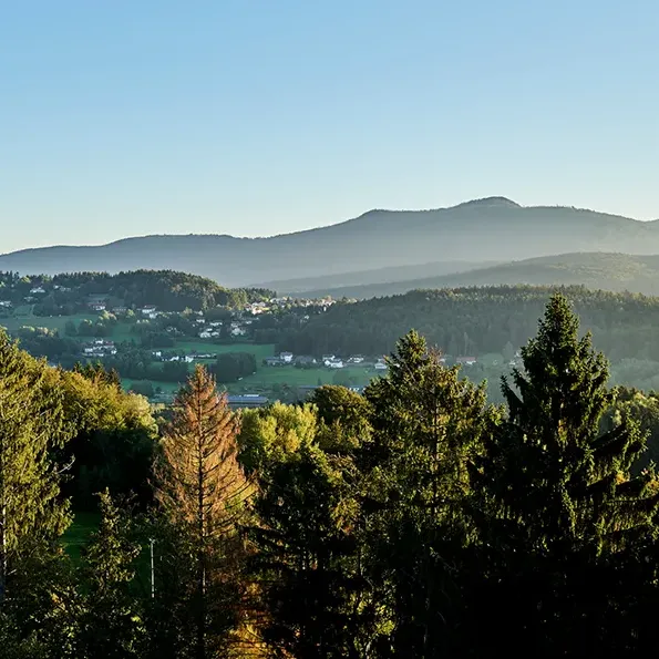 Der Große Rachel im Herbstnebel und davor liegend der Ort Spiegelau Spiegelau bei Sonnenuntergangmit dem Großen Rachel im Hintergrund