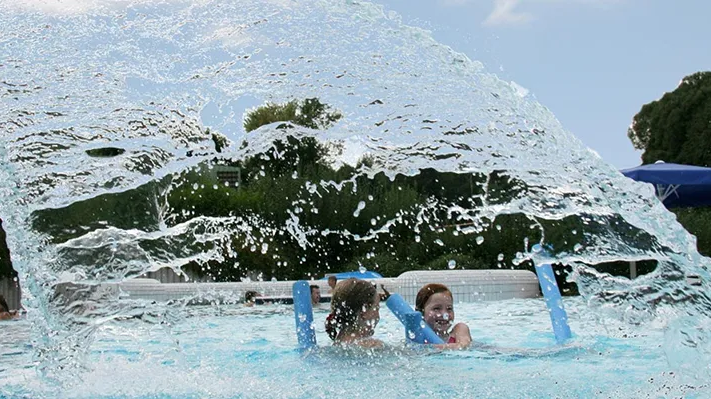 Plantschende Menschen im Becken Kinder beim Baden