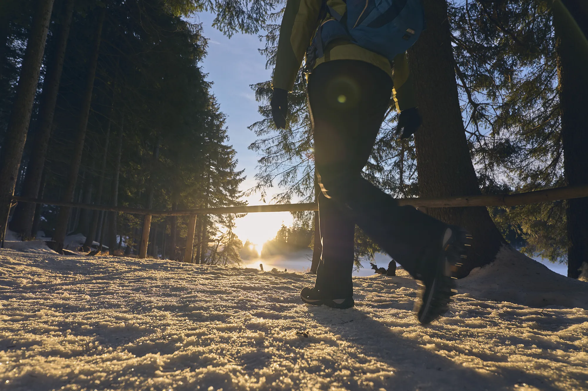 Fußgänger geht mit Grödeln auf einem verschneiten Winterweg